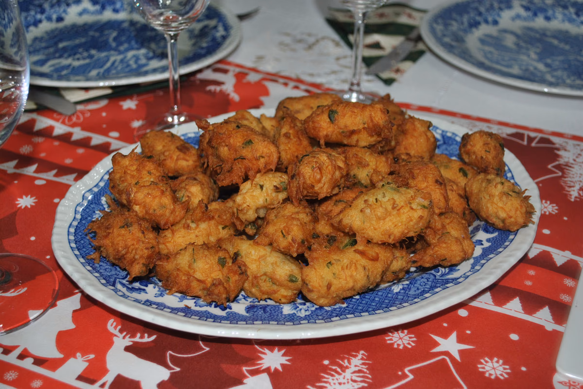 Travessa com bolinhos de bacalhau dourados e salpicados de salsinha