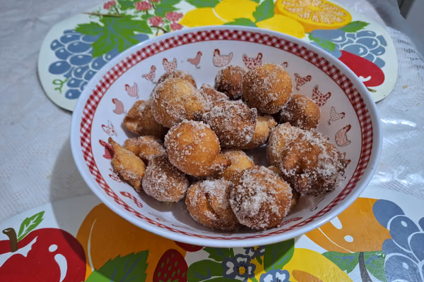 Tigela com bolinhos de chuva dourados cobertos de açúcar e canela