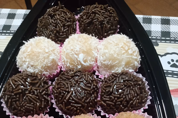 Bandeja com brigadeiros cobertos de granulado de chocolate e beijinhos com coco ralado