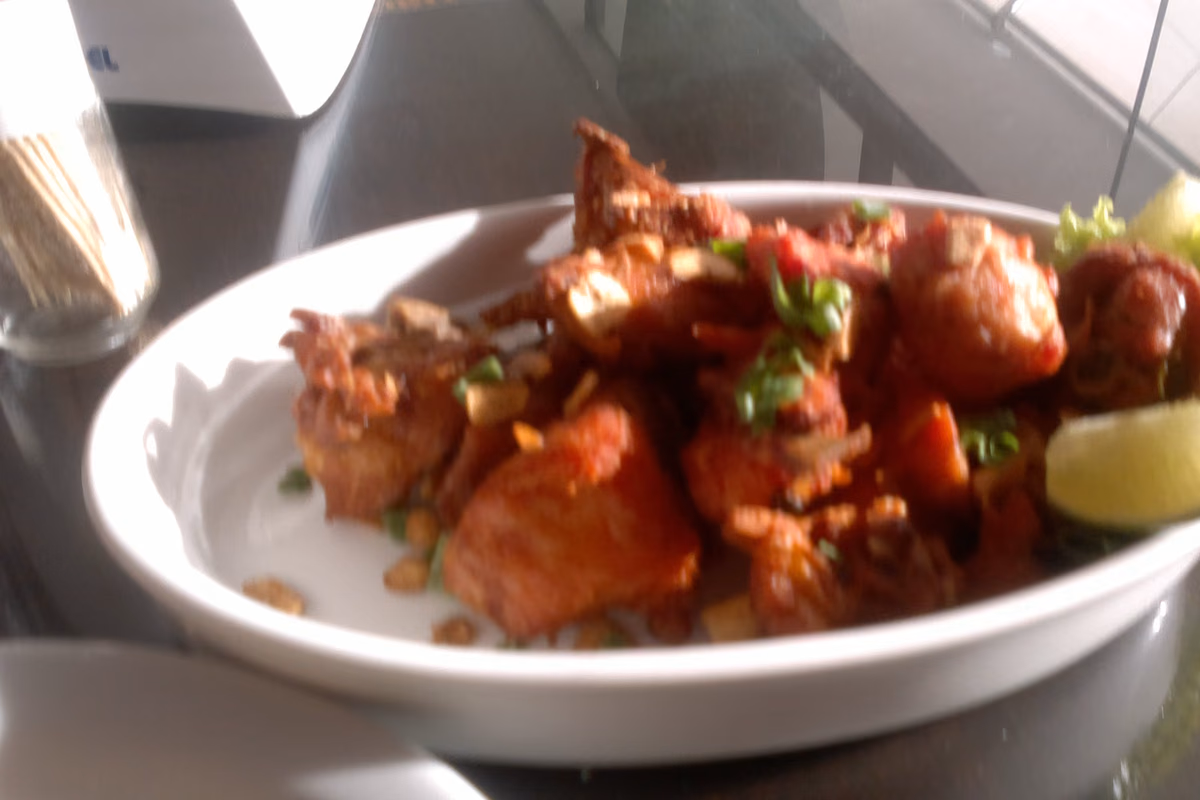 Tigela funda com pedaços de frango à passarinho dourados, salpicados de alho e salsa
