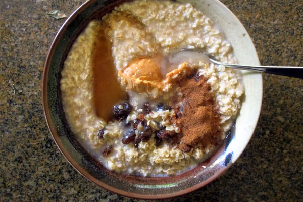 Tigela de mingau de aveia cremoso com frutas e sementes por cima